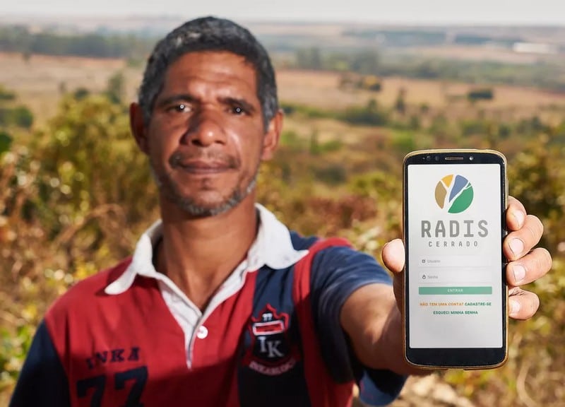 homem mostrando tela do celular com a tela inicial do aplicativo do projeto RADIS CERRADO